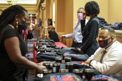 Attendees pick up items at a souvenir table on the first day of the NABJ/NAHJ 2022 Convention and Job Fair in Las Vegas, Nev., on Wednesday, August 03, 2022.